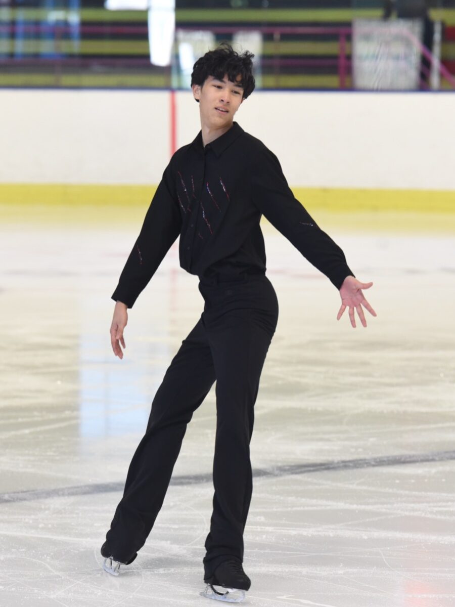 Patineur en tenue noire en position technique